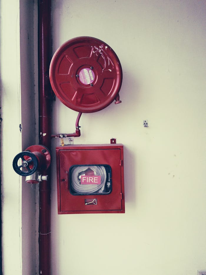 services-02 Red fire safety equipment on a white wall, essential for emergencies.